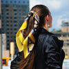 Astrology yellow and black scarf featuring the twelve zodiac signs  by ANNE TOURAINE Paris™ scarves tied on a ponytail