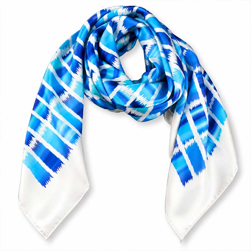 An Ethnic teal and navy large silk satin scarf by Anne Touraine Paris, draped in a loose loop on a clean white background.