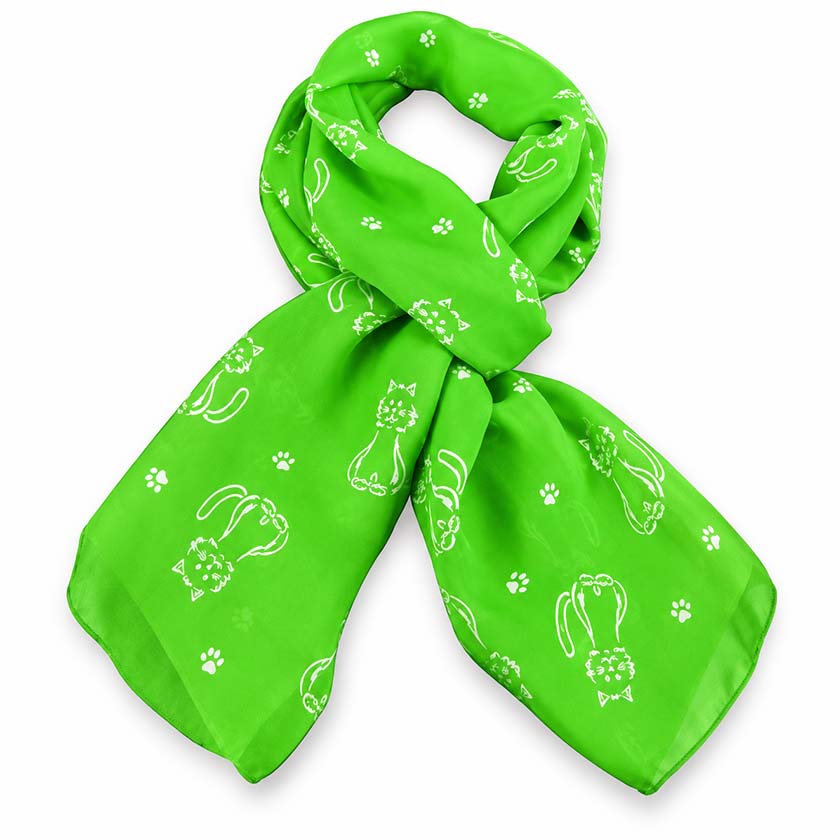 A bright green scarf in silk chiffon with a white pattern of cartoon cats and paw prints, styled in a loose knot on a white background. This is made by Anne Touraine Paris.