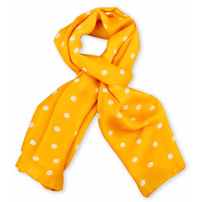 An orange Anne Touraine Paris silk chiffon stole with white polka dot pattern, styled in a loose knot on a plain white background.