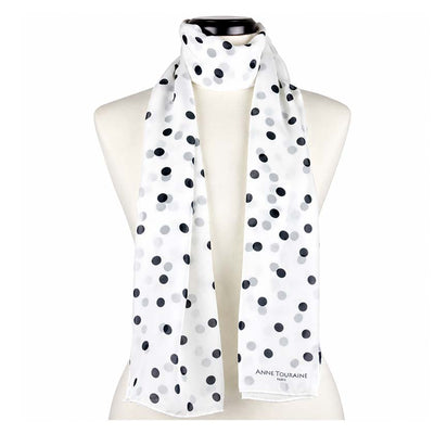 A white silk chiffon scarf with black polka dots, by Anne Touraine Paris, styled on a mannequin on a plain white background.
