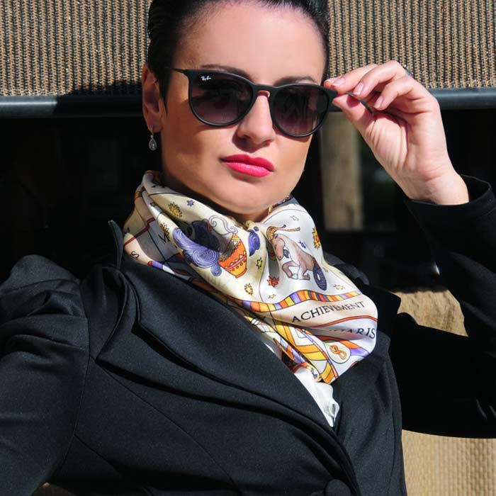 Astrology zodiac inspired scarves: white silk scarf featuring the twelve zodiac signs by ANNE TOURAINE Paris™. Scarf tied as a fluffy neck scarf